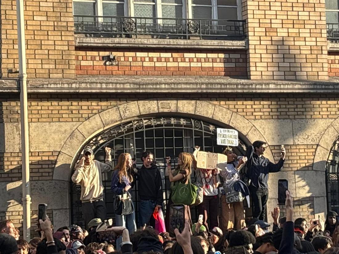Manifestants massés devant une grille d'école