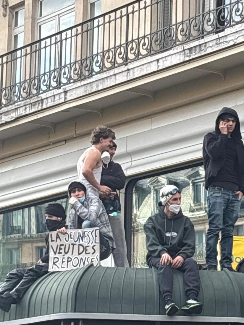 Manifestants perchés sur un abri, pancarte « La jeunesse veut des réponses »