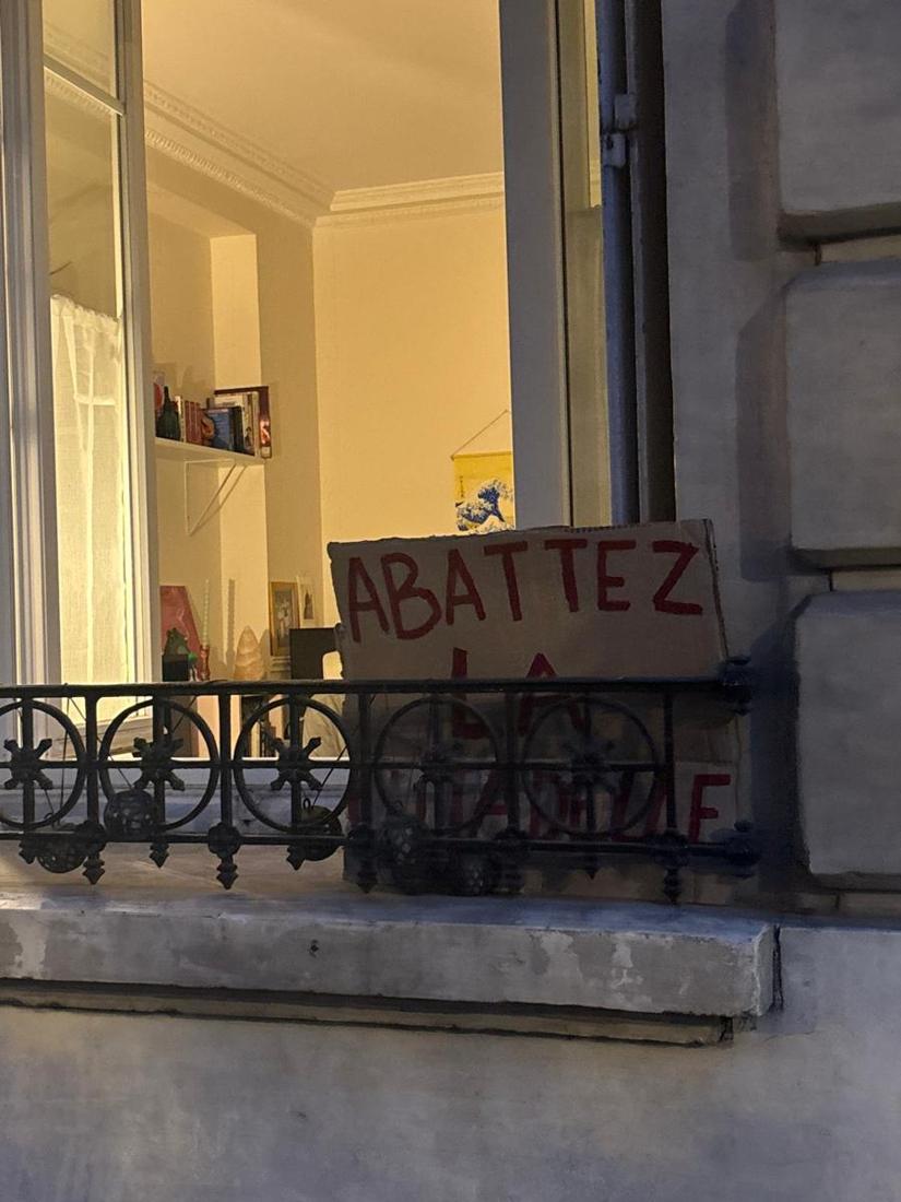 Pancarte posée sur un balcon en fer forgé