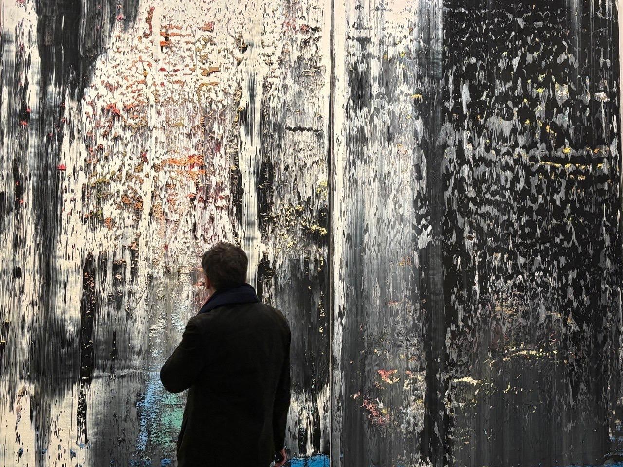 Visiteur face à une grande toile abstraite