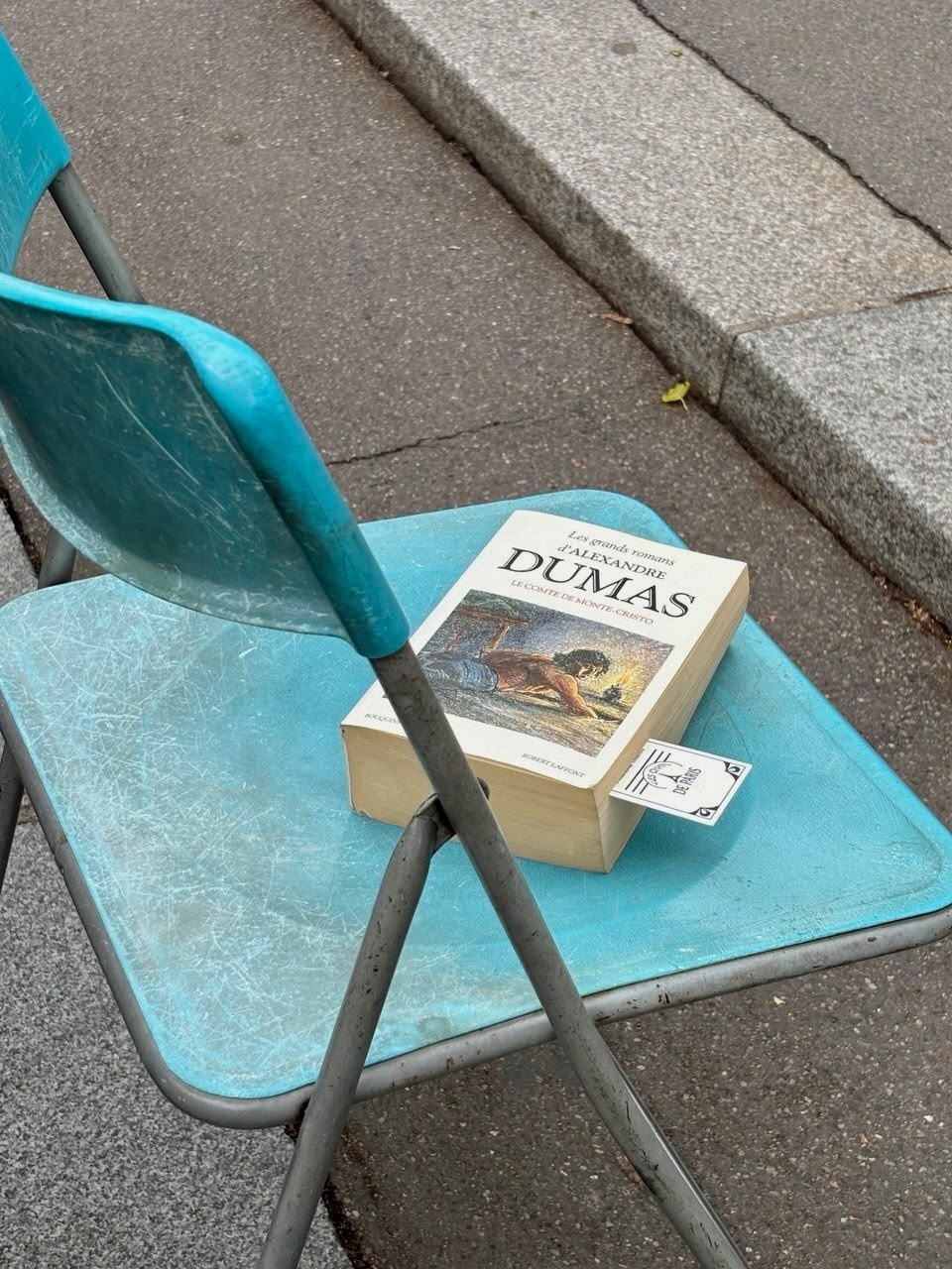 Livre posé sur une chaise bleue