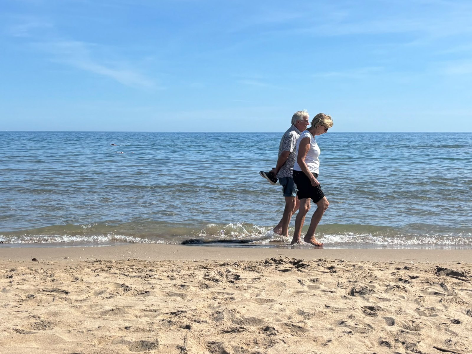Couple marchant pieds nus dans l'écume