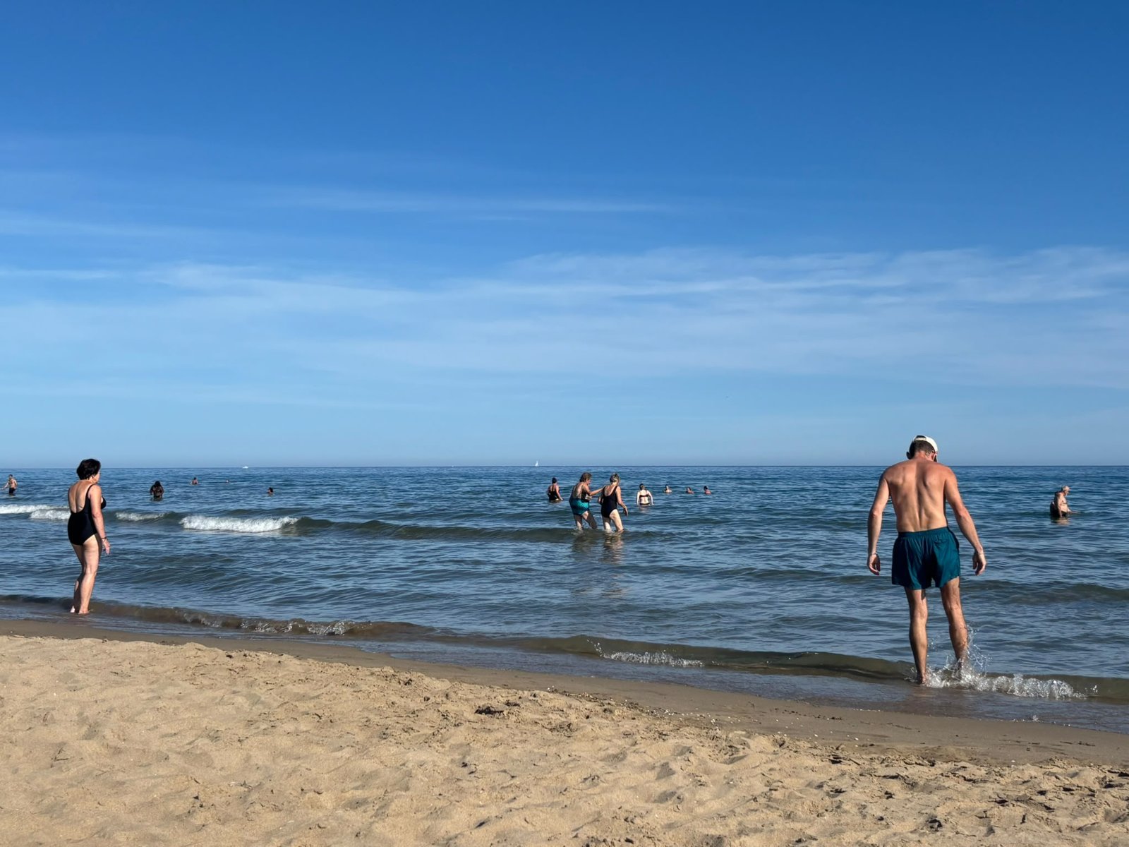 Baigneurs entrant dans une mer calme