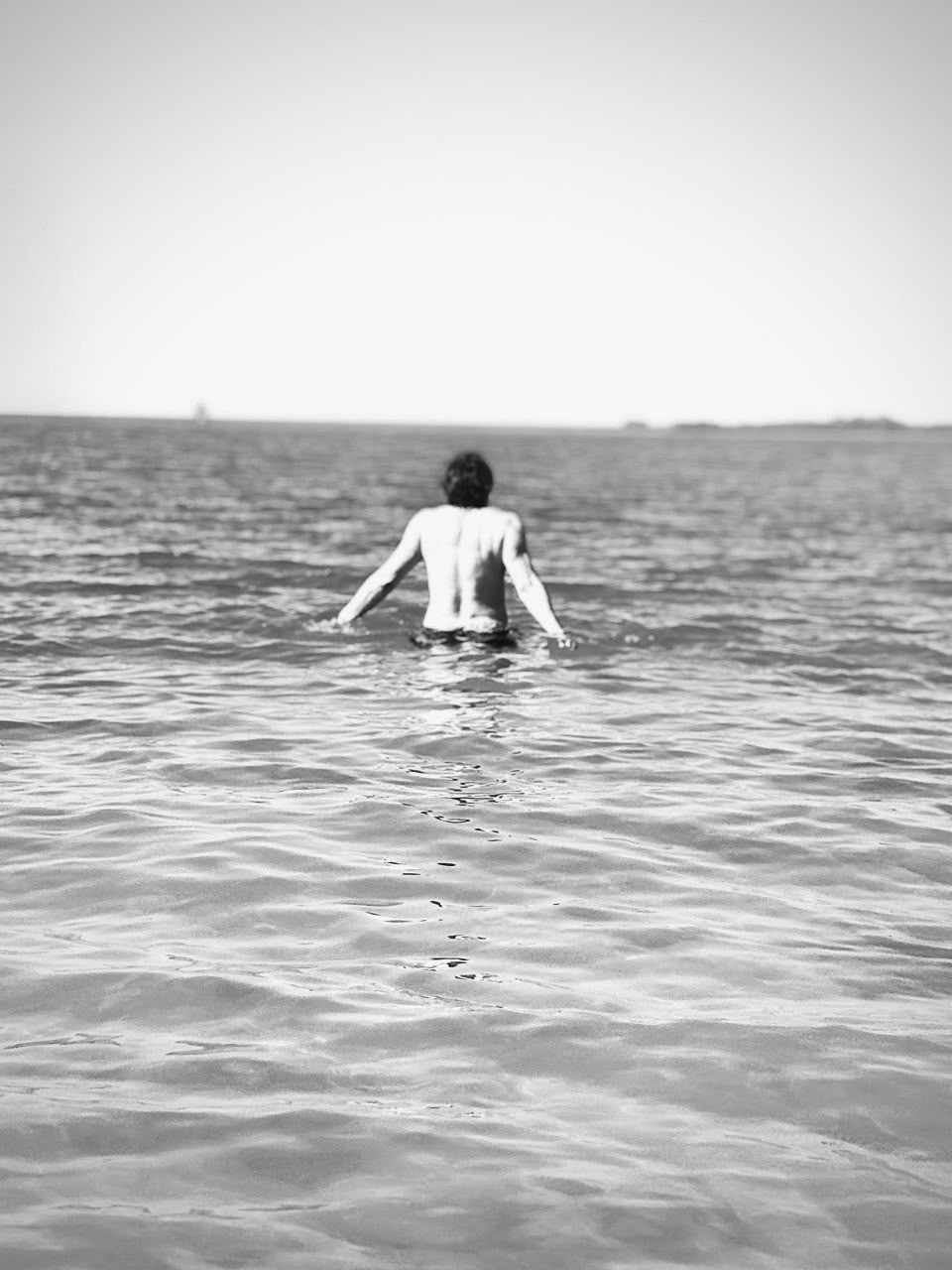 Silhouette de dos entrant dans la mer, noir et blanc